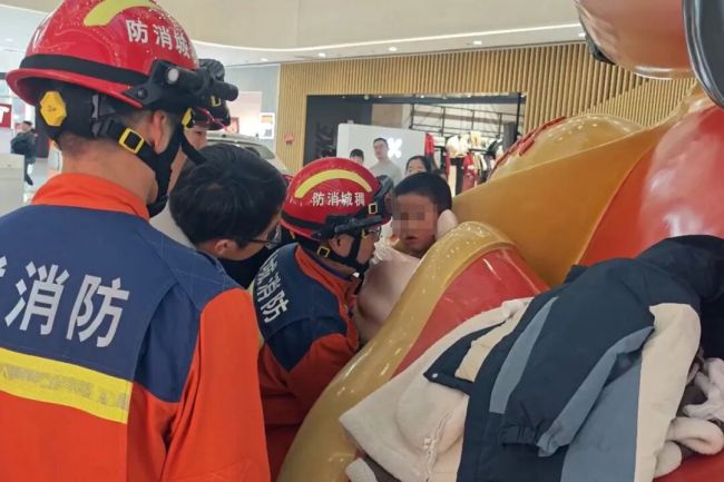 小孩哥卡在财神爷“掌心”出不来 好奇心引发的“尴尬”