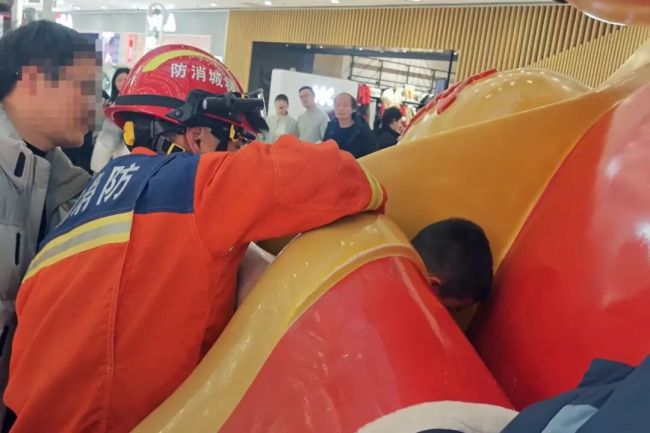 小孩哥卡在财神爷“掌心”出不来 好奇心引发的“尴尬”